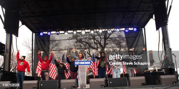 View of unidentified advocates against gun violence raise their arms as they speak from a stage during the March For Our Lives rally, Chicago,...