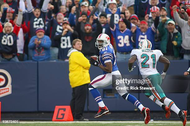 Terrell Owens of the Buffalo Bills crosses the goal line for a 51 yard touchdown ahead of Vontae Davis of the Miami Dolphins at Ralph Wilson Stadium...