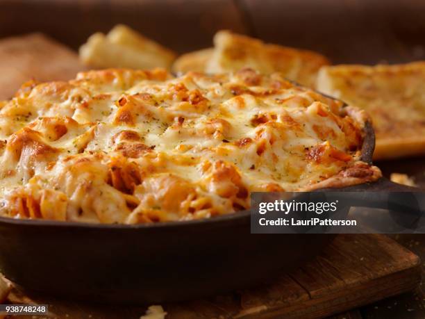 cheesy baked rotini pasta in roasted tomato and garlic sauce with garlic bread - macaroni stock pictures, royalty-free photos & images