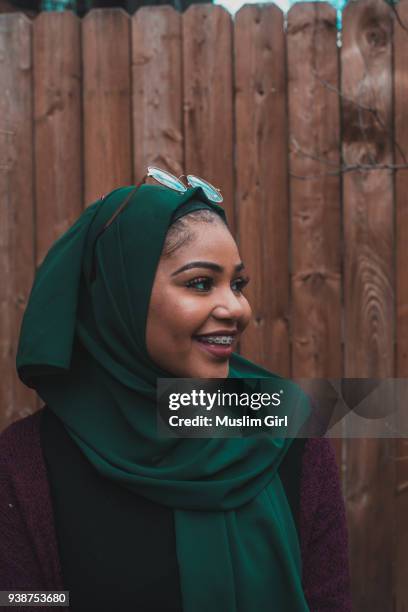 a cute muslim girl in jewel tone green hijab, smiling through her braces - muslimgirlcollection ストックフォトと画像