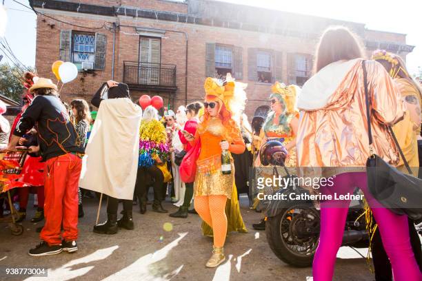 mardi gras street parade with woman in orange looking at her phone in a crowd - catherine ledner foto e immagini stock