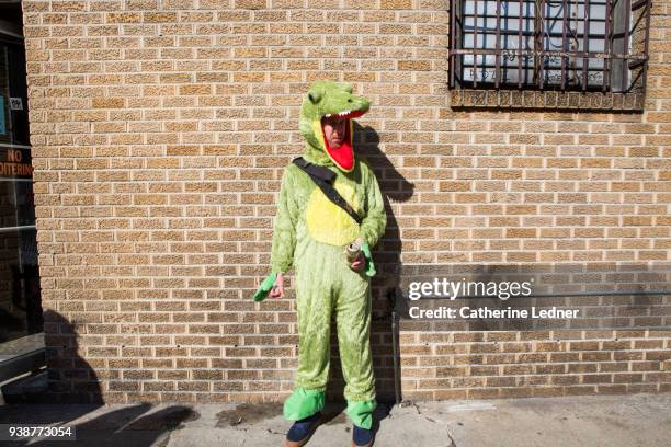 man in aligator costume smoking a cigarette and having a drink alone against brick wall - catherine ledner 個照片及圖片檔