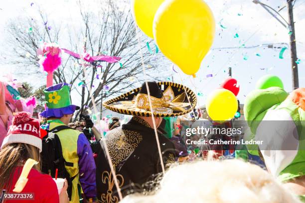 crowd of costumed mardi gras revelers.  man with sombrero and yellow balloons stands out - catherine ledner 個照片及圖片檔