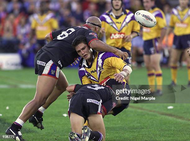 Storm player Henry Perenara has the ball knocked out by Jeryy Seu Seu and P.J. Marsh of the Warriors during the National Rugby League Match between...