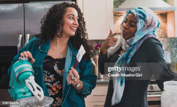 two muslim women tasting cake frosting - robot da cucina foto e immagini stock