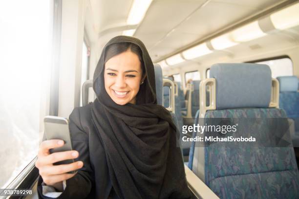 muslim business women commuting on the train - niqab stock pictures, royalty-free photos & images