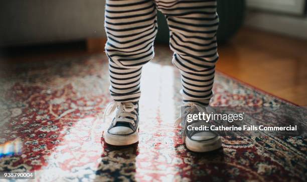 toddler wearing sneakers - striped pants stock-fotos und bilder