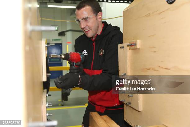 Sunderland player John O'Shea on the assembly line during a visit to the Caterpillar factory in Peterlee, Sunderland on March 27, 2018 in Sunderland,...