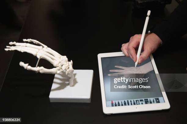 Guest draws the bones of the hand on Apple's new 9.7-inch iPad during an event held to introduce the device at Lane Tech College Prep High School on...