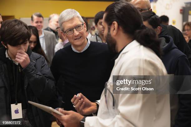 Apple CEO Tim Cook gets a demonstration of an app during an event held to introduce the new 9.7-inch Apple iPad at Lane Tech College Prep High School...