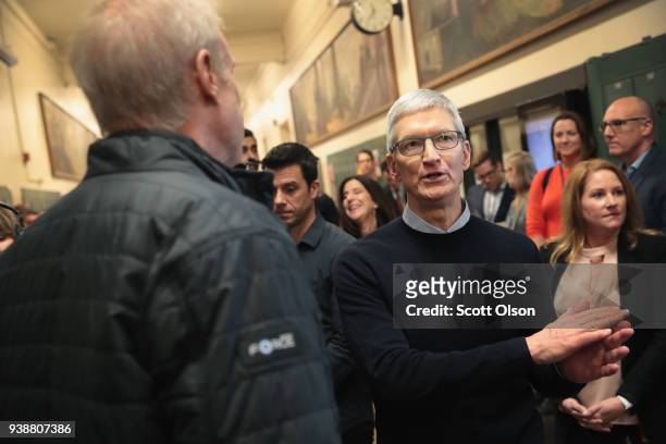 Apple CEO Tim Cook chats with Illinois Governor Bruce Rauner during an event held to introduce the new 9.7-inch Apple iPad at Lane Tech College Prep...