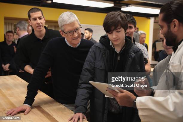 Apple CEO Tim Cook gets a demonstration of an app during an event held to introduce the new 9.7-inch Apple iPad at Lane Tech College Prep High School...
