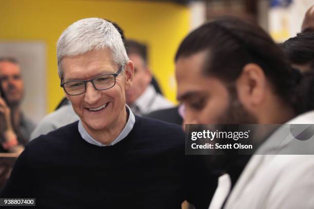 Apple CEO Tim Cook gets a demonstration of an app during an event held to introduce the new 9.7-inch Apple iPad at Lane Tech College Prep High School...