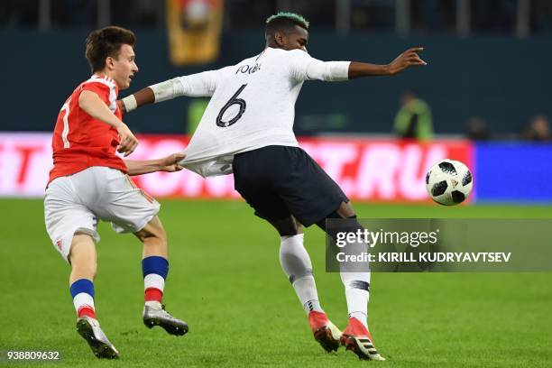 Russia's midfielder Alexander Golovin and France's midfielder Paul Pogba vie for the ball during an international friendly football match between...