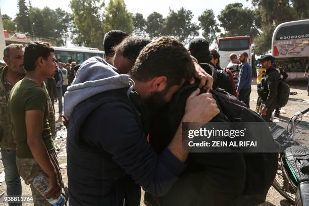 Syrian men evacuated from Eastern Ghouta embrace upon arriving in the village of Qalaat al-Madiq, some 45 kilometres northwest of the central city of...