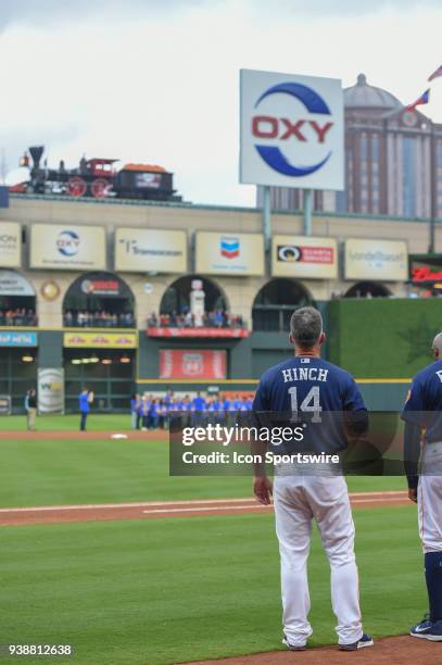 Houston Astros manager A.J. Hinch stands for the National Anthem as a choir sings from shallow center field before the game between the Milwaukee...