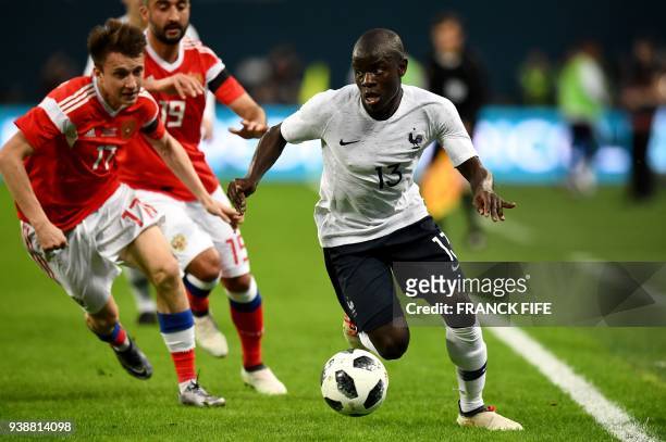 Russia's midfielder Alexander Golovin, Russia's midfielder Alexander Samedov and France's midfielder N'golo Kante vie for the ball during an...