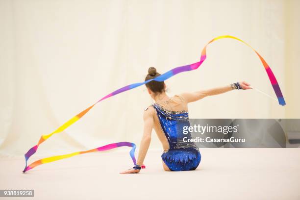 jonge ritmische gymnastiek atleet dansen met lint - ritmische-gymnastiek stockfoto's en -beelden