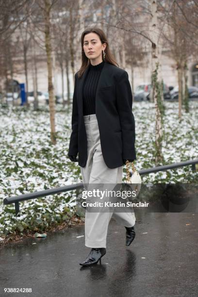 Fashion blogger Sylvia Haghjoo wears an Uzwei jumper, Chloé trousers and bag, Loewe shoes, Céline jacket and Hermes earrings day 4 of Paris Womens...