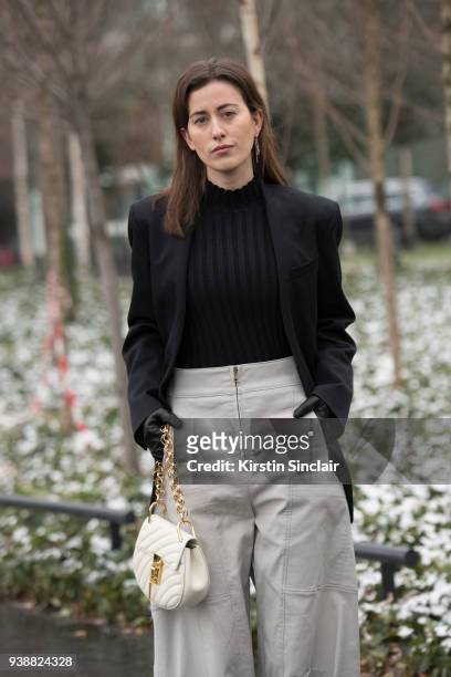 Fashion blogger Sylvia Haghjoo wears an Uzwei jumper, Chloé trousers and bag, Céline jacket and Hermes earrings day 4 of Paris Womens Fashion Week...