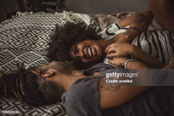 in bed and in love - couple cuddling in bed stock pictures, royalty-free photos & images