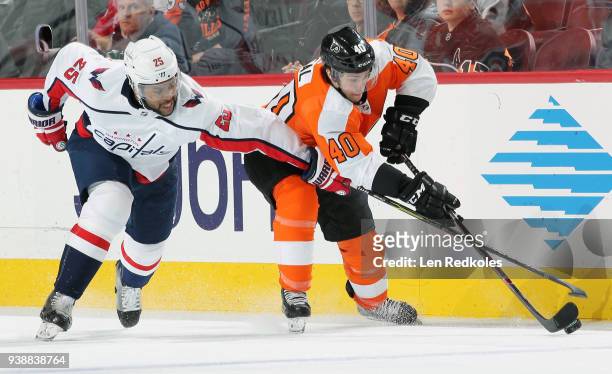 Jordan Weal of the Philadelphia Flyers battles for the puck against Devante Smith-Pelly of the Washington Capitals on March 18, 2018 at the Wells...