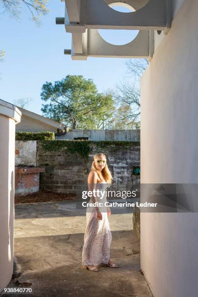 young blonde with mask over eyes standing in a concrete environment - catherine ledner 個照片及圖片檔