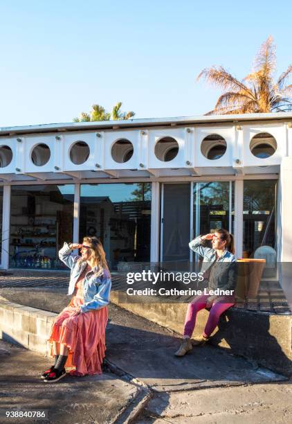 two young women holding up their hands to block the sunset in their eyes. - catherine ledner foto e immagini stock