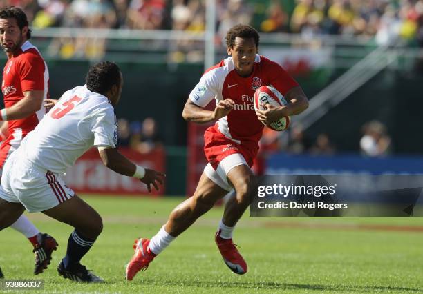 Dan Norton of England breaks away to score one of his three tries against the USA during the IRB Sevens tournament at the Dubai Sevens Stadium on...