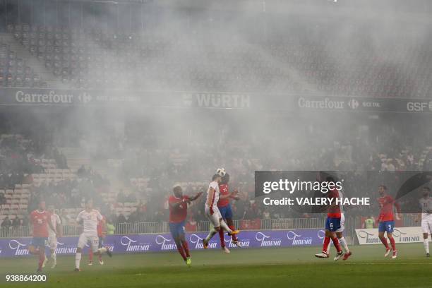 Players play as supporters burn flares causing smoke during the international friendly football match between Tunisia vs Costa Rica on March 27, 2018...