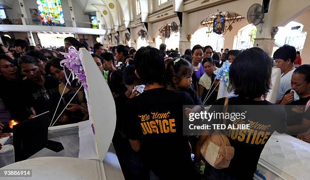 Relatives of slain journalists mourn over the coffins after the funeral mass in General Santos City, south Cotabato province on December 4, 2009....