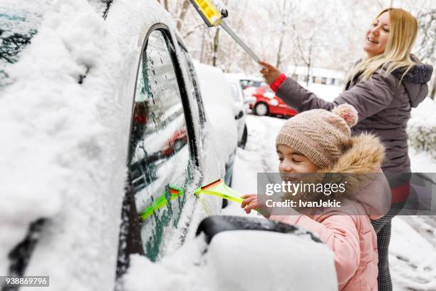 familie, die beseitigung von schnee von ihrem auto zusammen - city cleaning stock-fotos und bilder