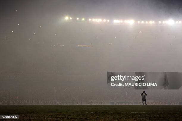 Carlos Espinola, of Ecuador's Liga Deportivo de Quito, stands on the pitch amid smoke coming from fireworks shot by fans of Brazil's Fluminense at...