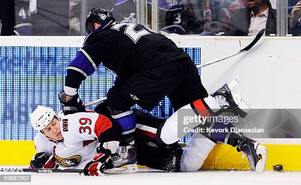 Matt Carkner of the Ottawa Senators is checked as he falls to the ice by Jarret Stoll of the Los Angeles Kings during third period of the NHL hockey...