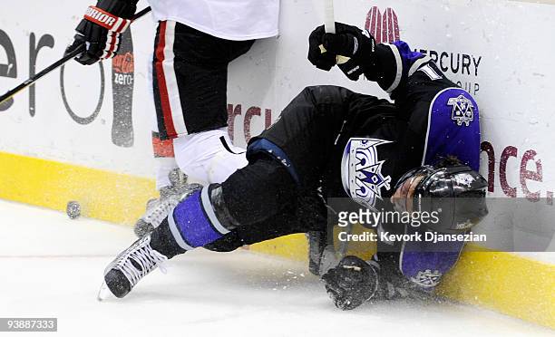 Anze Kopitar of the Los Angeles Kings crashes against the boards as Chris Phillips of the Ottawa Senators defends during third period of the NHL...