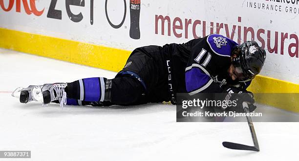 Anze Kopitar of the Los Angeles Kings crashes against the boards as Chris Phillips of the Ottawa Senators defends during third period of the NHL...