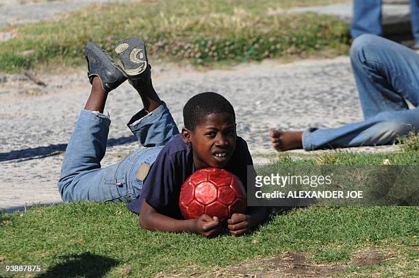 Boy watches a football match in the Gugulethu township outside of Cape Town on December 2, 2009. With the draw for the World Cup 2010 turning Cape...