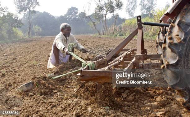 Farmer sits on a plough in his wheat field in the village of Bijnor, India, on Thursday, Dec. 3, 2009. India, the world's second-biggest producer of...