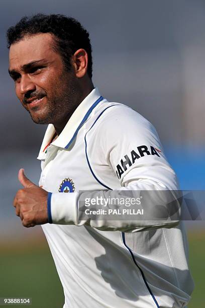 Indian cricketer Virendra Sehwag gives a thumbs up on his way to the pavillion after scoring double century on the second day of the third test...