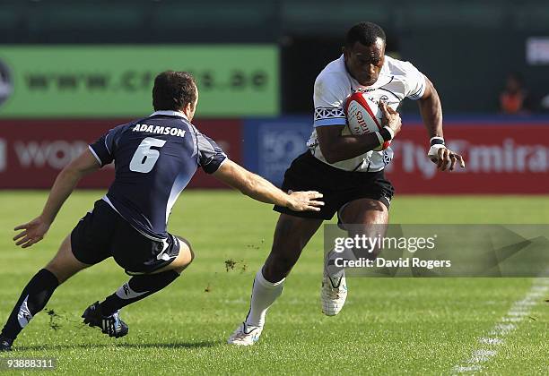 Setefano Cakau of Fiji moves away from Mike Adamson of Scotland during the IRB Sevens tournament at the Dubai Sevens Stadium on December 4, 2009 in...
