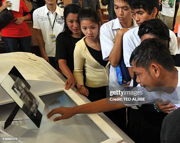 The son of a slain journalist tries to reach the portrait of his mother after the funeral mass in General Santos City, south Cotabato province on...