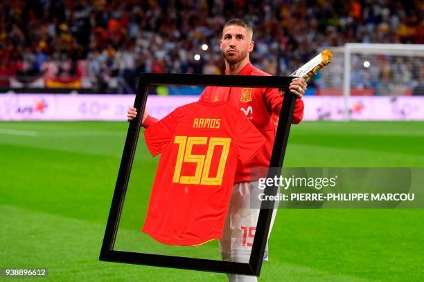 Spain's defender Sergio Ramos poses with a special framed jersey marking his 150th cap for Spain before a friendly football match between Spain and...