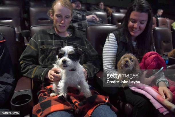 Nathan Burns with Higgins and Anne Marie Stevenson with Bisous sit in their seats before the Sneak preview of Wes Andersons new film, Isle of Dogs,...