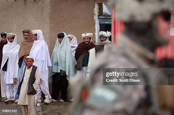 Locals watch soldiers from the Army's Blackfoot Company 1st Battalion 501st Parachute Infantry Regiment patrol through the business district on...