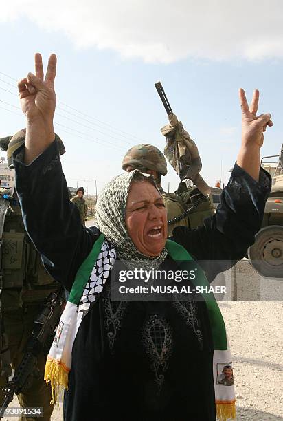 Palestinian woman shouts slogans during a demonstration against Israel's separation barrier in the West Bank village of Maasarah, near the...