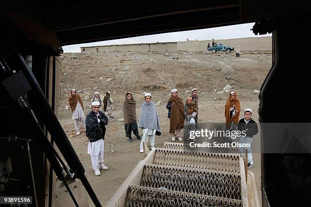 Children gather and watch as soldiers from the Army's Blackfoot Company 1st Battalion 501st Parachute Infantry Regiment prepare to leave in a MRAP...