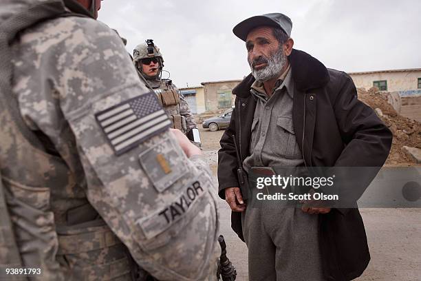 Afghan National Police District Chief of Police Zahir Dad speaks with 2nd Lt. Josh Taylor of Nixa, MO and SGT Michael Phillips Hemet, CA from the...