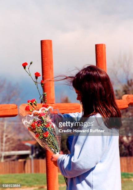 Young girl places flowers upon crosses erected in remembrance of victims at Columbine High School, Littleton, Colorado, April 21, 1999. Two former...