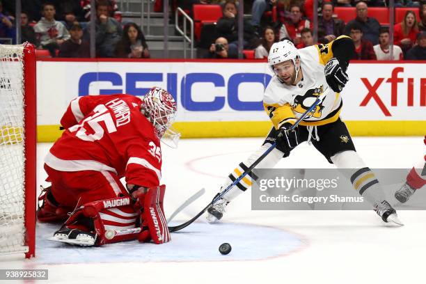 Jimmy Howard of the Detroit Red Wings makes a first period save on a shot by Bryan Rust of the Pittsburgh Penguins at Little Caesars Arena on March...