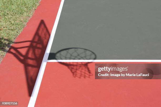 shadow of basketball hoop on court - basketball net stockfoto's en -beelden